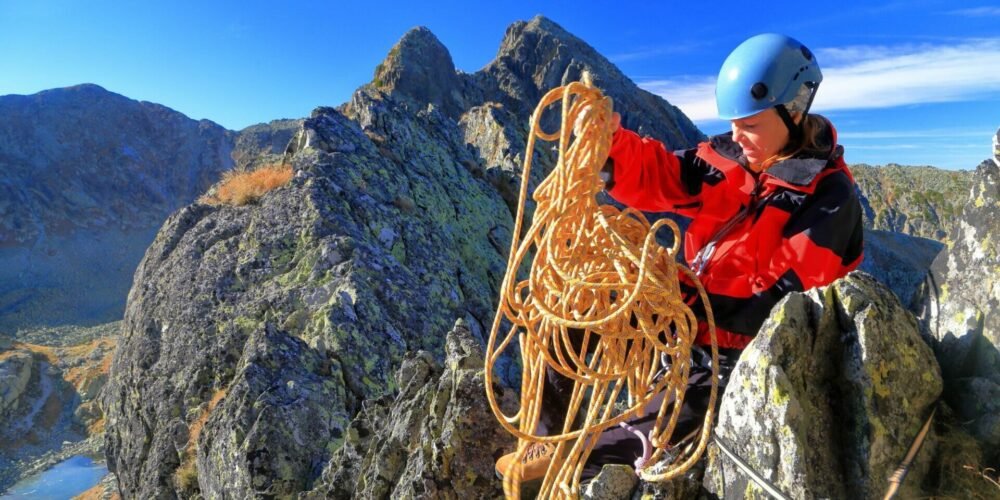 persoon die touw bewerkt tijdens het beklimmen van een berg